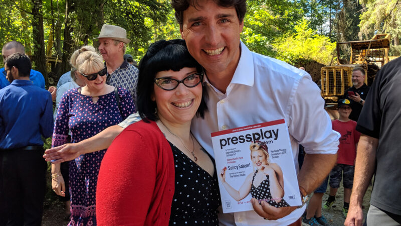 Carlee Wright standing with Canada's PM Justin Trudeau holding a copy of Press Play Salem